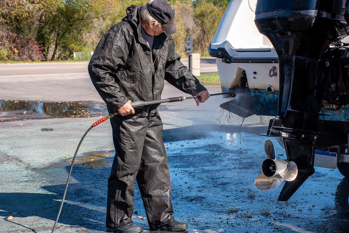 Caucasian man power washing boat